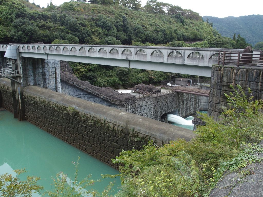 石小屋ダムの堤体越しに愛川第2発電所の放流