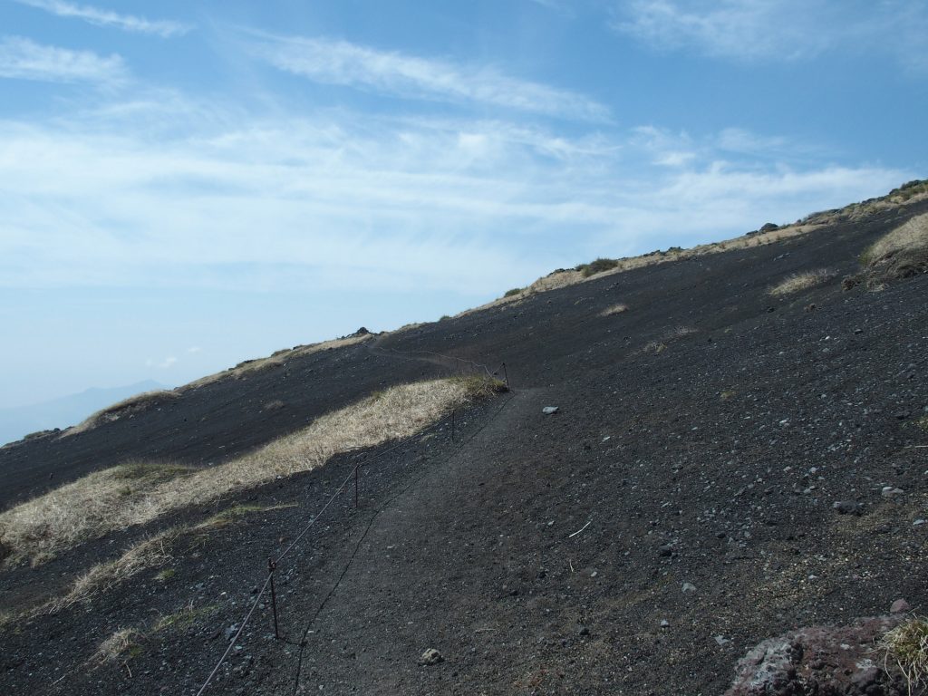 火山礫の斜面にロープが続く